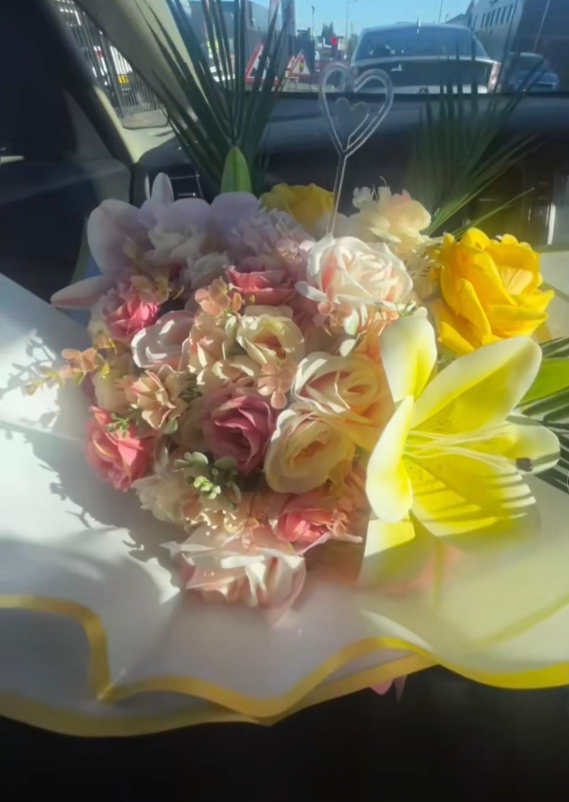 Pastel artificial bouquet of blush roses, orchids and yellow lilies with a heart pick
